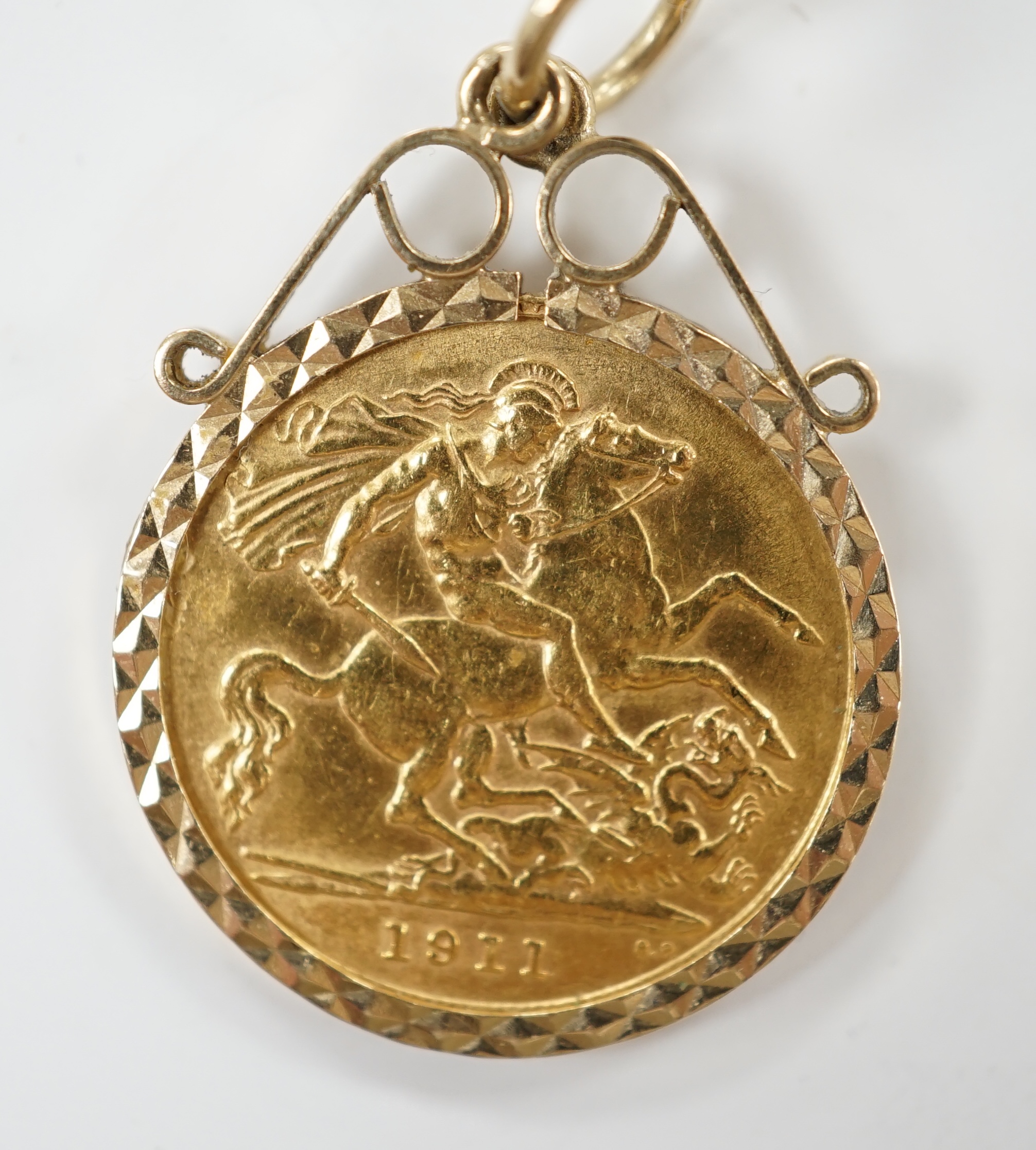 A George V 1911 gold half sovereign, in a later 9ct gold pendant mount